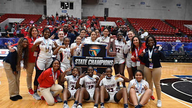Miami Country Day players gather around their trophy after winning the  Class 3A state championship at the RP Funding Center in Lakeland on Friday. 